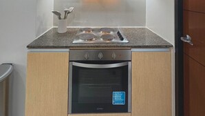 Una cocina compacta equipada con estufa a gas, horno y microondas.