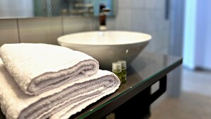 A bathroom with a large sink, a mirror, and a towel stack. - Appartement 10B - MyResidenced'Azur (Beausoleil)