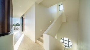 Ein modernes Interieur mit Treppe, Oberlicht und Blick ins Freie.