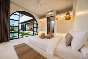 A modern bedroom with a large bed, a view of a pool, and an open-plan design. - Large 3 Bedroom Villa in Prime Uluwatu with Pool and Free Airport Pickup (South Kuta)