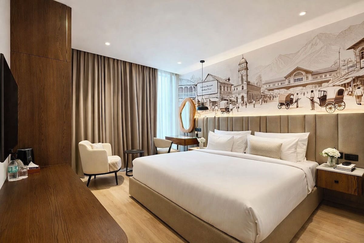A hotel room with a large bed, a desk, a chair, a mirror, and a wall mural.