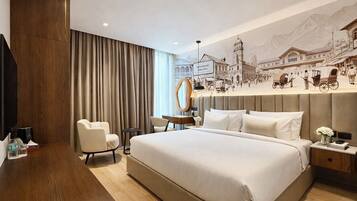 A hotel room with a large bed, a desk, a chair, a mirror, and a wall mural.