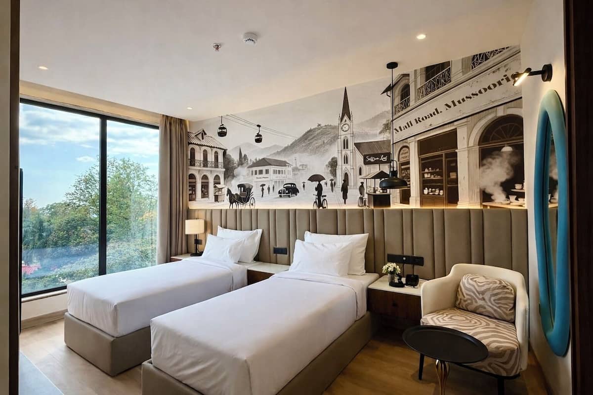 A hotel room with two beds, a sofa, a small table, a view of the outdoors, and a mural depicting a historical scene.