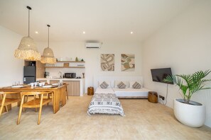 A modern living space with a dining area, kitchenette, and a sofa set. - 2BR Nunggalan Villa with Pool & Rooftop (South Kuta)