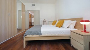 Ein Schlafzimmer mit einem Bett, einem Nachttisch und einer Lampe.