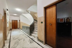 A marble-floored hallway with a wooden door and a staircase. - Monteverde - Large and comfortable apartment for 8 (Roma)