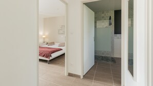 Une chambre à coucher avec un lit, une table de chevet et une commode.