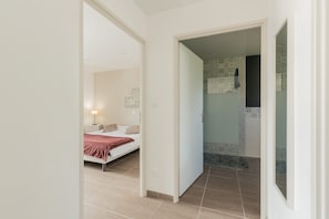 Un dormitorio con cama, mesita de noche y velador.