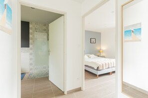 A bedroom with a bed, a bedside table, a lamp, and a wall with a framed picture. - Holiday Home 'Le T'chot Pierre 2' with Lake View, Private Terrace and Wi-Fi (Saint-Quentin-en-Tourmont)