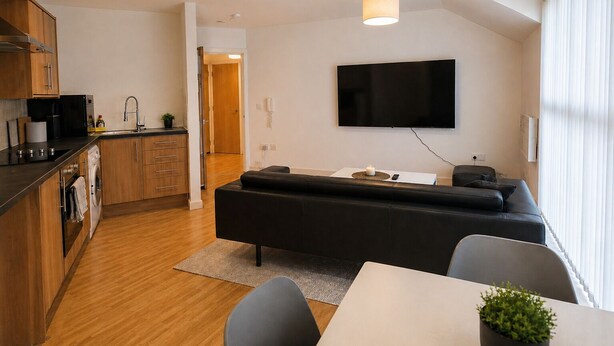 A modern living space with a kitchen, a sofa, a TV, and a dining area. - Webster Road Park Loft Apartment (Liverpool)