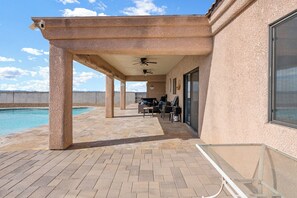 A covered outdoor area with a pool, seating, and a ceiling fan. - Sabino Gorgeous Heatable Pool Retreat (Lake Havasu City)