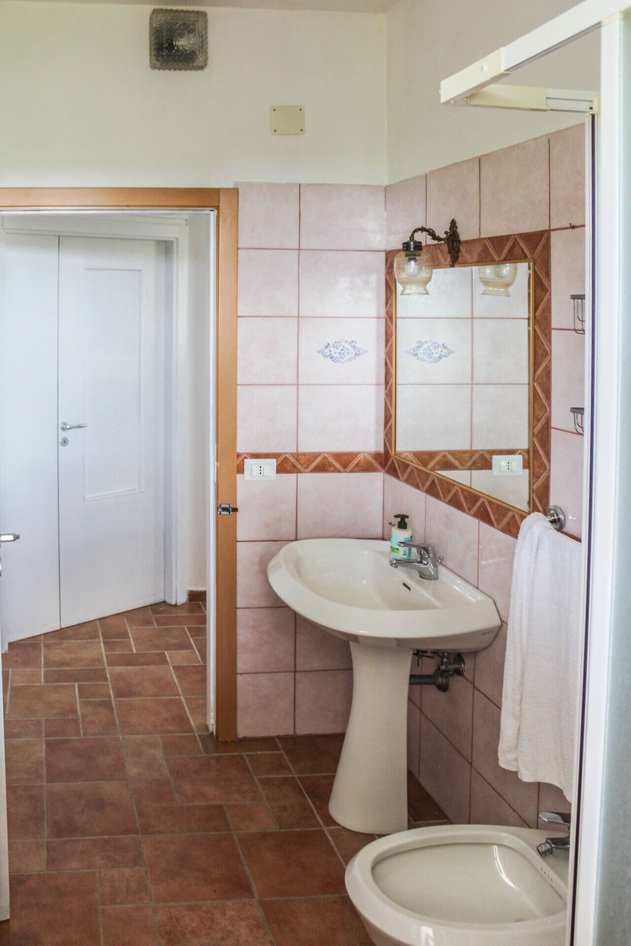 A bathroom with a white sink, a toilet, and a shower area.