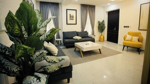 Ein modernes Wohnzimmer mit einer Couch, einem Couchtisch und einem gelben Sessel.