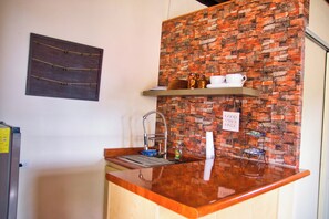 A kitchen with a brick backsplash, a sink, and a coffee station. - Cozy Loft studio with views of Downtown Tijuana (Tijuana)