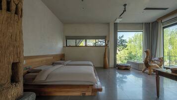 Ein modernes Schlafzimmer mit einem großen Bett, einem Holzkopfende, einem Fenster und Blick auf Bäume.