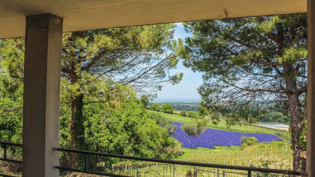 A covered outdoor area with a view of solar panels and trees. - La Casa di Pippo (Pollutri)