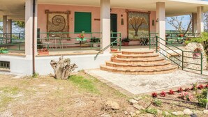 A covered outdoor area with a staircase leading to a door, potted plants, and a tiled patio. - La Casa di Pippo (Pollutri)