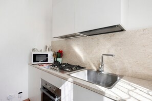 Réfrigérateur, un four, surface de cuisson, vaisselle et ustensiles