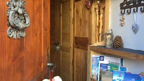 A wooden door with a decorative handle, a heart-shaped decoration, and a shelf with books and a pine cone. - Your summer retreat in the heart of the mountains, services included (Aime-la-Plagne)