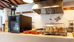 A kitchen with a refrigerator, a waffle maker, and a coffee machine. - Hotel Emblemático Duque de la Torre (Arona)