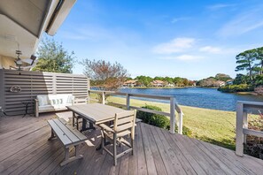 Eine Holterrasse mit Tisch und Bänken, mit Blick auf einen See und Häuser im Hintergrund.
