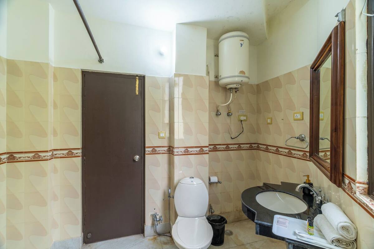 Uma casa de banho com sanita, lavatório e espelho.
