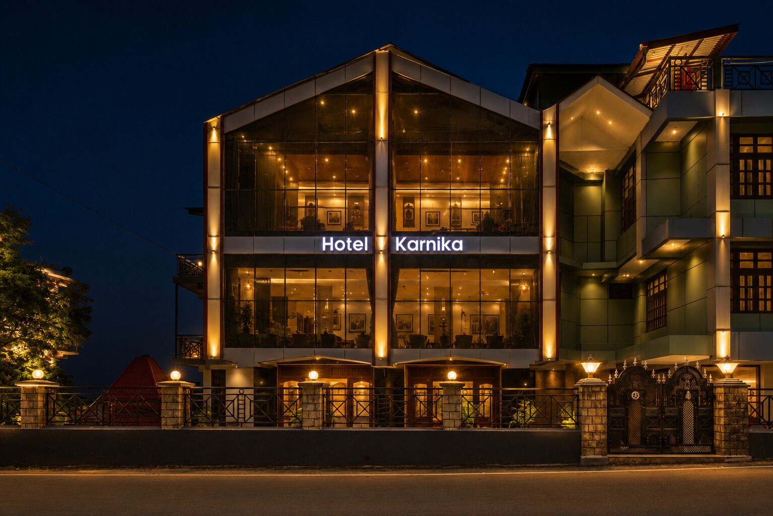 A hotel with a modern facade, large glass windows, and a sign indicating it's named 'Hotel Karnika.'