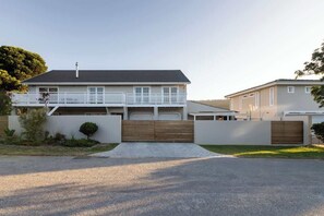 Ein zweistöckiges Haus mit Balkon, Garage und Auffahrt.