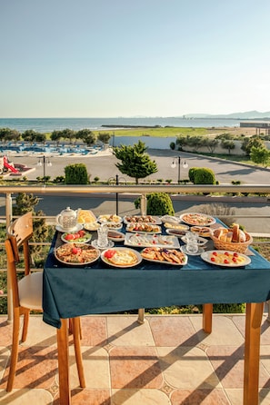 A table set with various dishes and a view of a body of water and distant landscape.