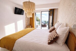 Ein Schlafzimmer mit Bett, einem an der Wand befestigten Fernseher und Blick durch die Tür.