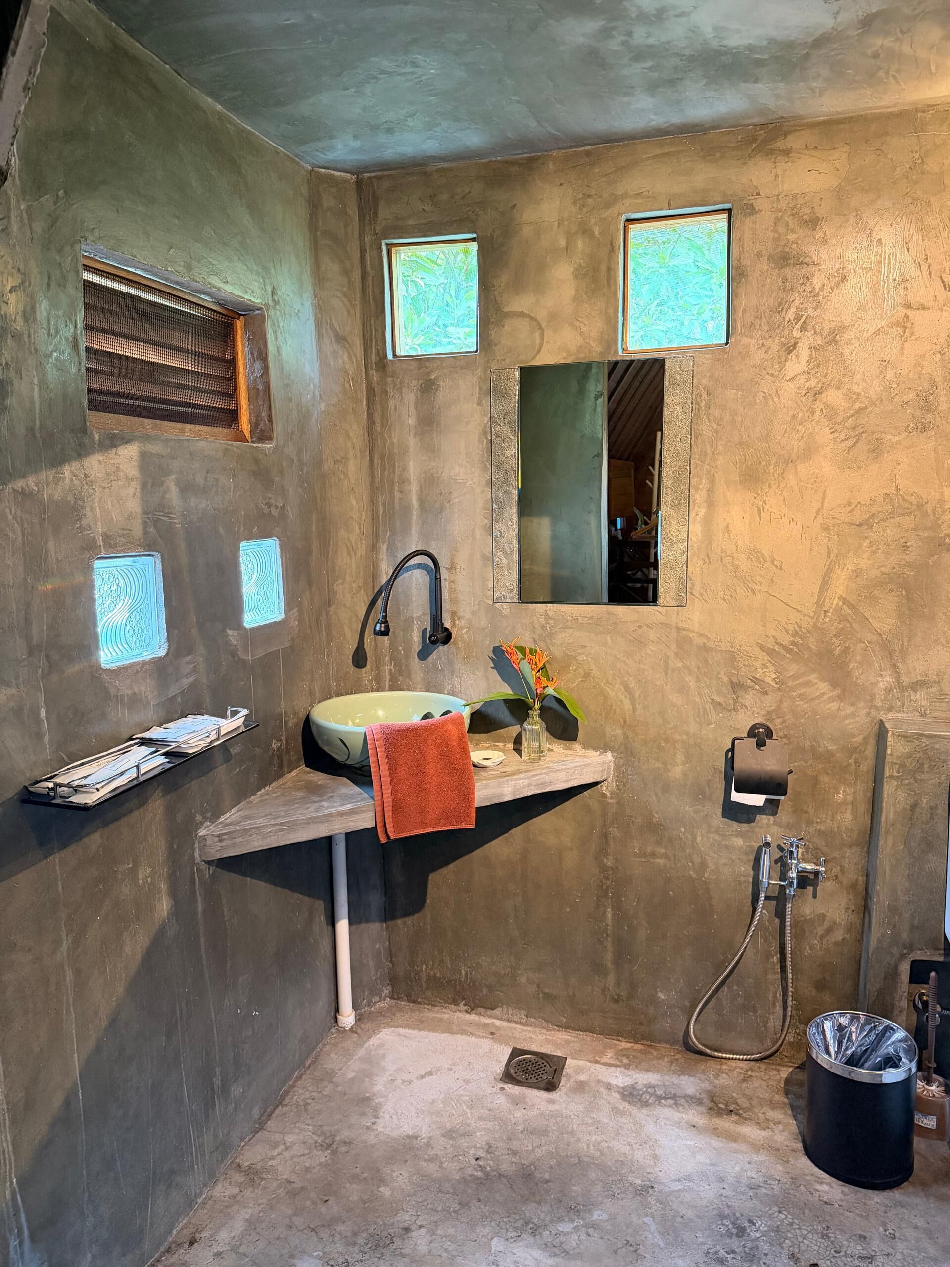 Ein Badezimmer mit Waschbecken, Spiegel, Handtuch und Dusche.
