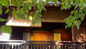 A wooden two-story building with a balcony, wooden railings, and a lattice design. - Golden Chenang Village (Langkawi)
