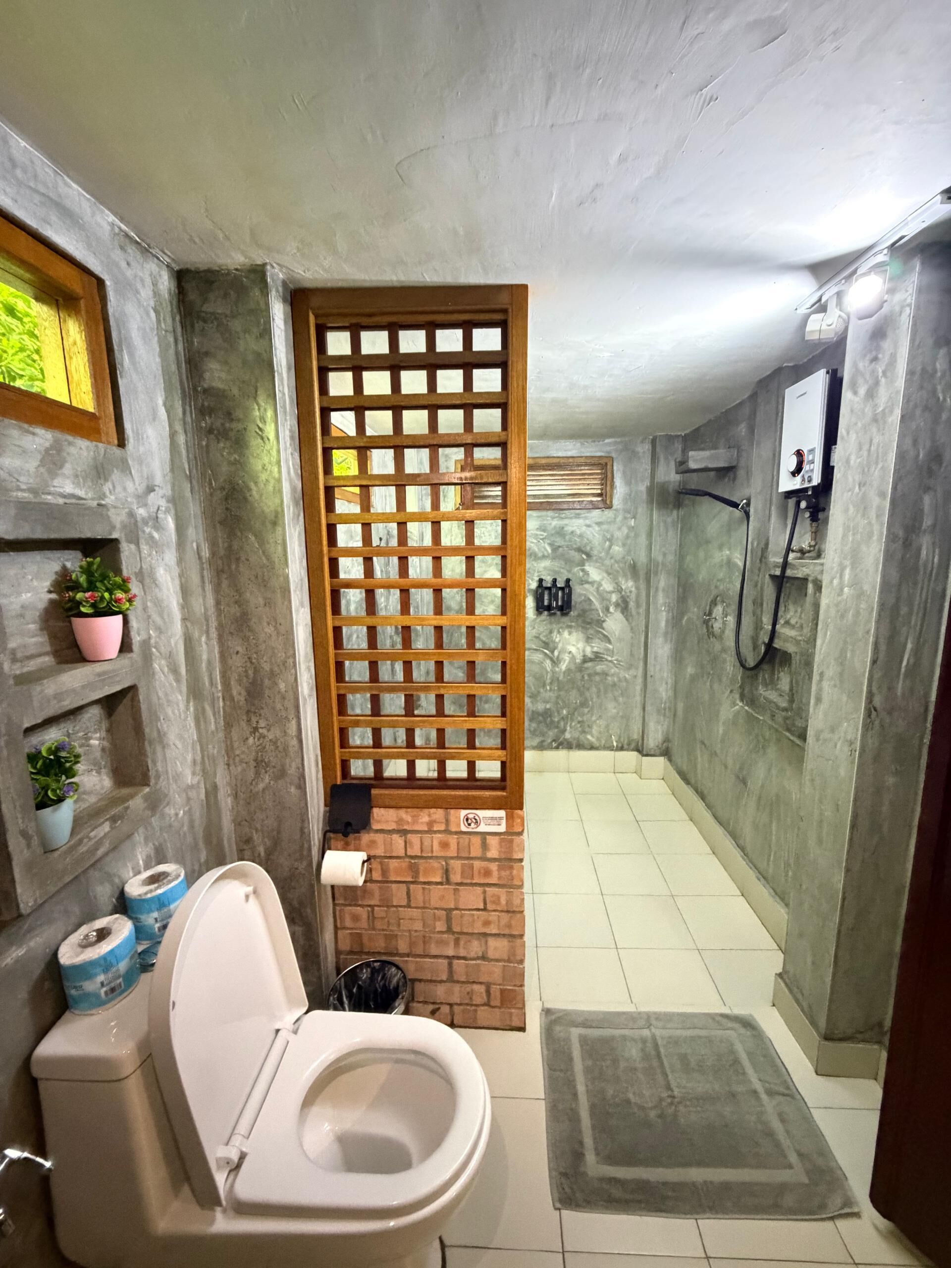 Une salle de bain avec des toilettes, une douche et un lavabo.