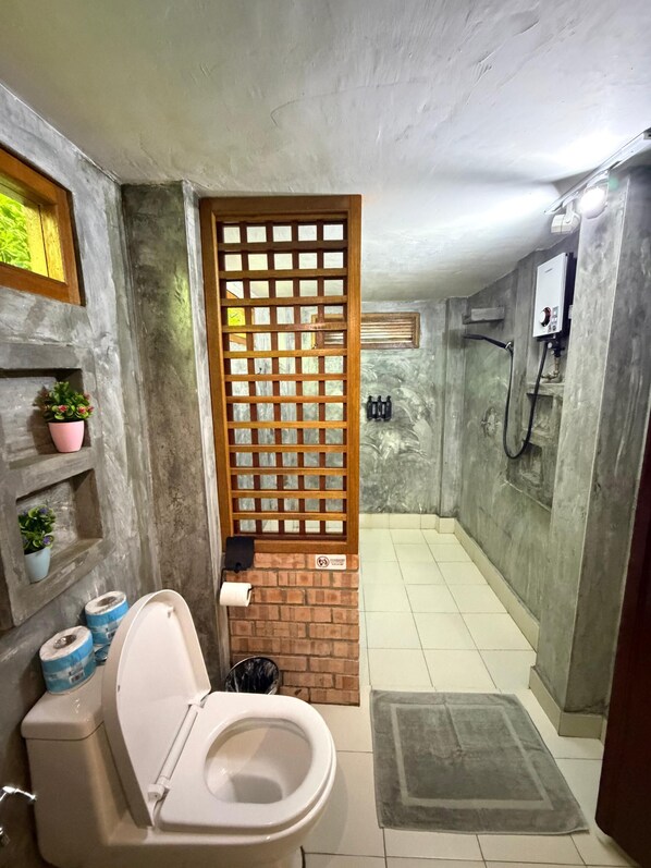 A bathroom with a toilet, a shower, and a sink. - Golden Chenang Village (Langkawi)