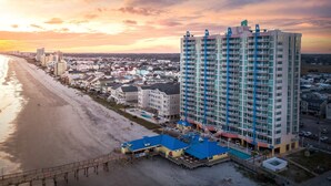 A coastal hotel with multiple floors, a beach view, and a pool area. - Cozy 2-bedroom apartment with AC in pleasant North Myrtle Beach Prince (North Myrtle Beach)
