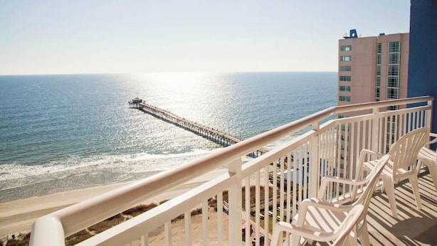 Un balcón con vista al océano y un muelle.