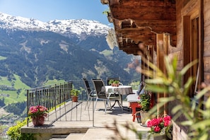 Un chalet en bois doté d’un balcon donnant sur un paysage montagneux.