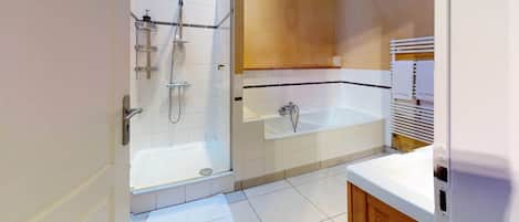Un baño con ducha, bañera y lavamanos.