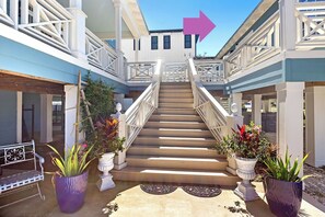 A multi-level building with a central staircase, potted plants, and a metal bench. - Coastal Cottage Retreat | Pool, Boat Dock, & Minutes to Pirates Cove (Elberta)
