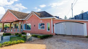 Une maison à deux étages dotée d’un porche abrité, d’un garage et d’un jardin bien entretenu.