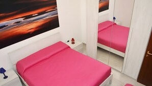 A bedroom with a single bed, a nightstand, a red lantern, and a mirror. - Marylu' Holiday Home in Torre Specchia (Torre Specchia Ruggeri)