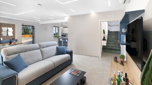 Uma sala de estar moderna com sofá, mesa de centro e televisão de tela plana.