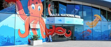 A building with a large octopus mural on the facade, labeled "MALTA NATIONAL AQUARIUM."