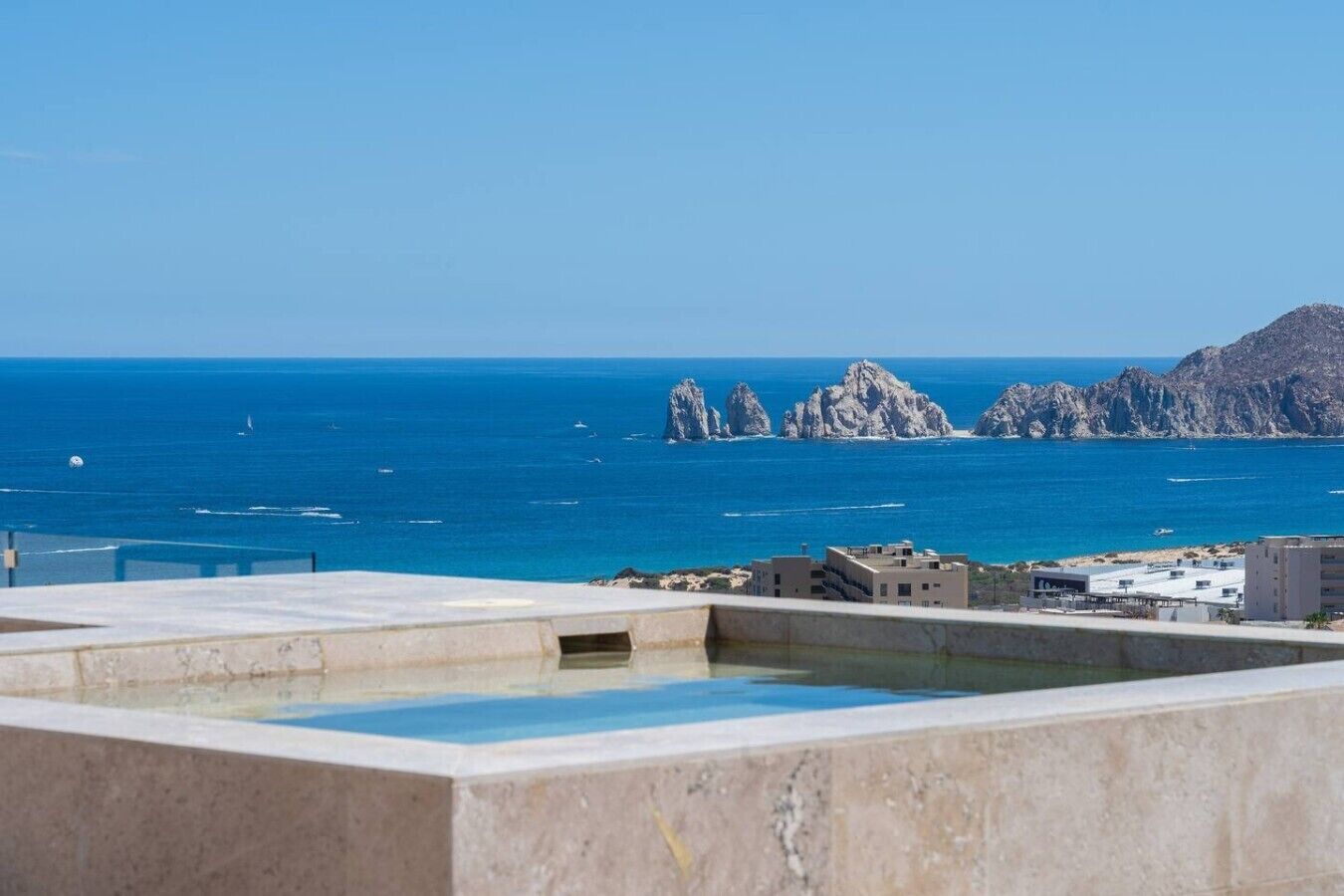 Une piscine sur le toit offrant une vue sur la mer et les formations rocheuses.