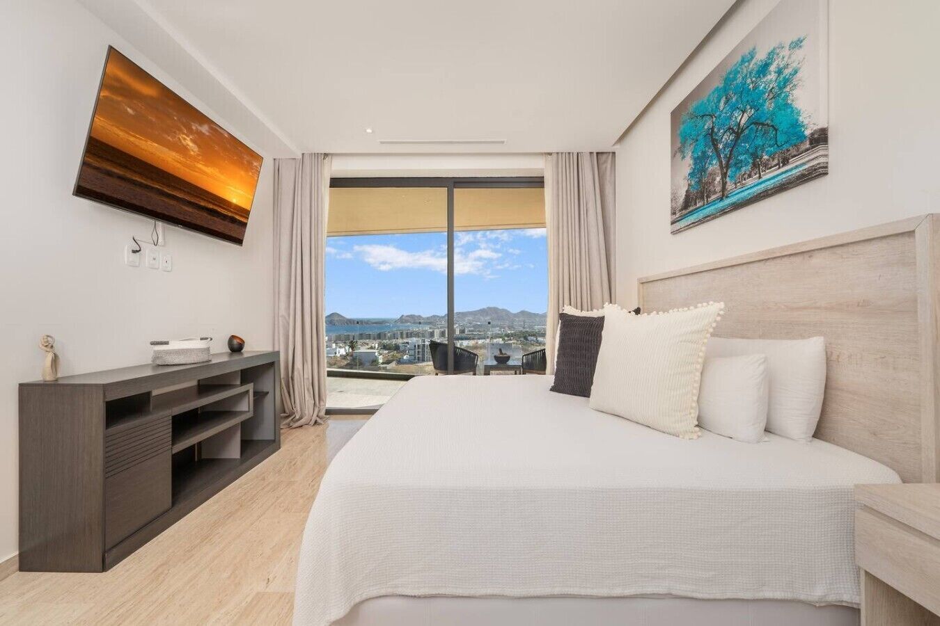 Une chambre d’hôtel moderne équipée d’un grand lit, d’un téléviseur à écran plat, d’un bureau et d’un tableau.