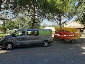 A silver van parked in a parking lot with a row of canoes on a trailer behind it. - Mobile home - 5 guests (Nonette-Orsonnette-Nonette)