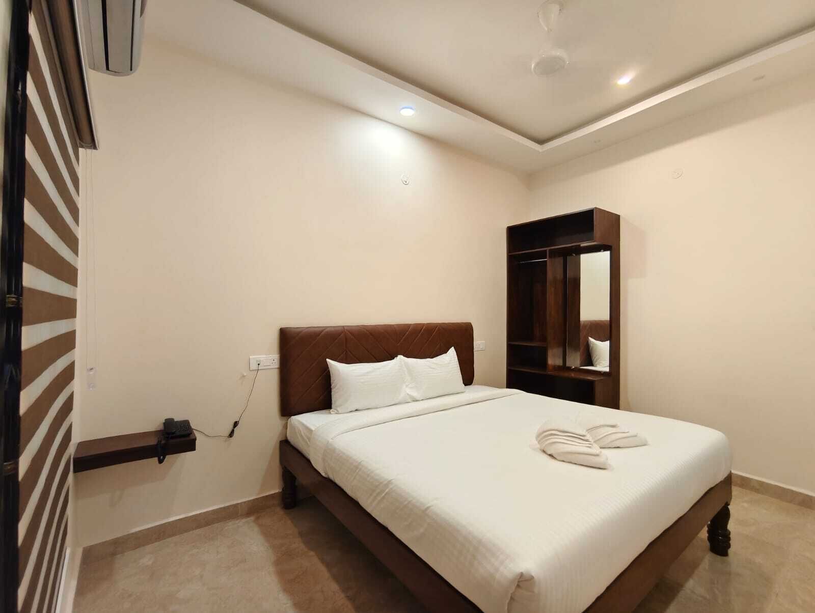 A bedroom with a bed, a wardrobe, and a mirror.
