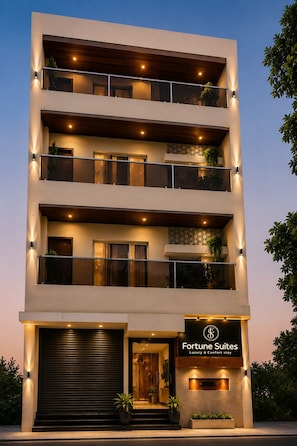 Un immeuble à plusieurs étages, sur lequel on peut lire l’inscription « Fortune Suites », ce qui indique qu’il propose un hébergement de luxe.