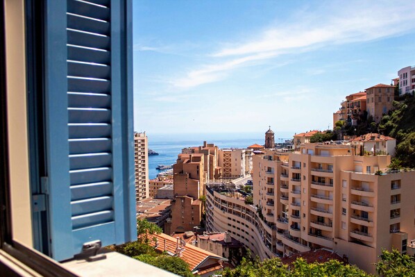 A coastal cityscape with multi-story buildings, balconies, and a clear view of the sea. - Appartement 6A - MyResidenced'Azur (Beausoleil)