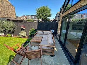 A patio with a wooden bench, a wooden table, and a sofa. - Cosy & Bright  2-Bed House in Earlsfield (London)